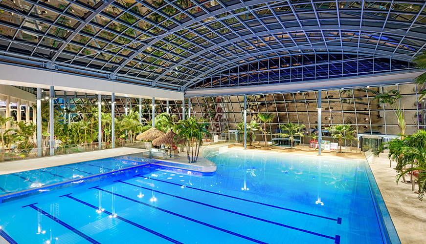 An expansive indoor swimming pool, covered by a roof, perfect for year-round aquatic activities.