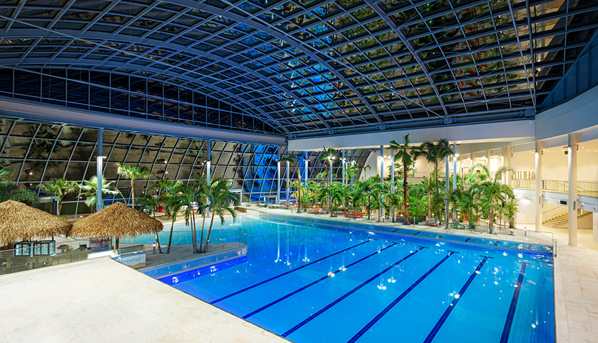 An expansive indoor swimming pool, covered by a roof, perfect for year-round aquatic activities.