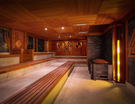 A cozy sauna room, featuring a Viking-inspired design with wooden benches and warm, inviting lighting.